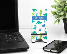 Load image into Gallery viewer, Dinosaur Cell Phone Stand. Custom Phone Stand, Dino phone stand, Gift for teacher, iphone holder, cell phone holder, charging stand
